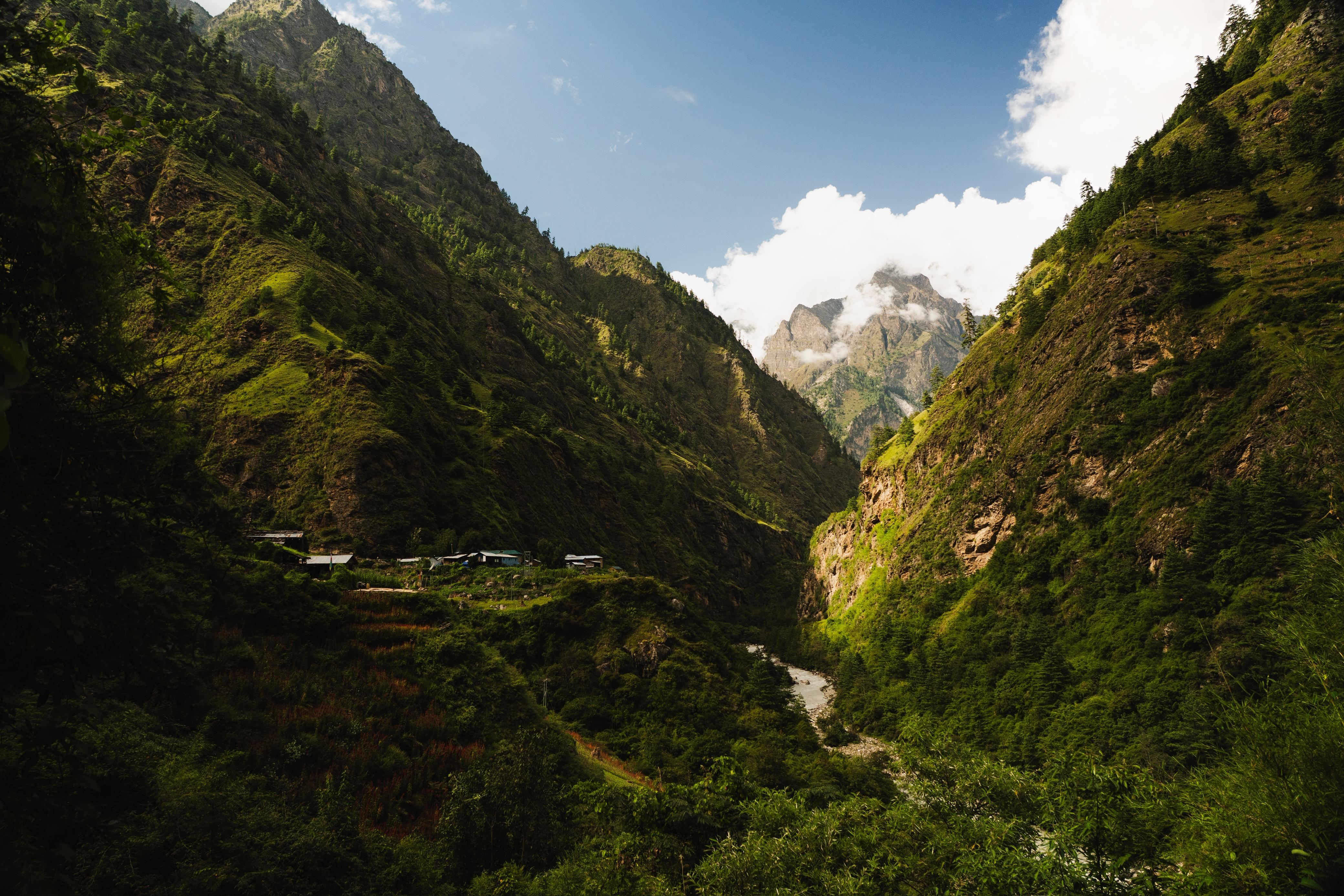 Lush green valley with river cutting through steep mountain walls