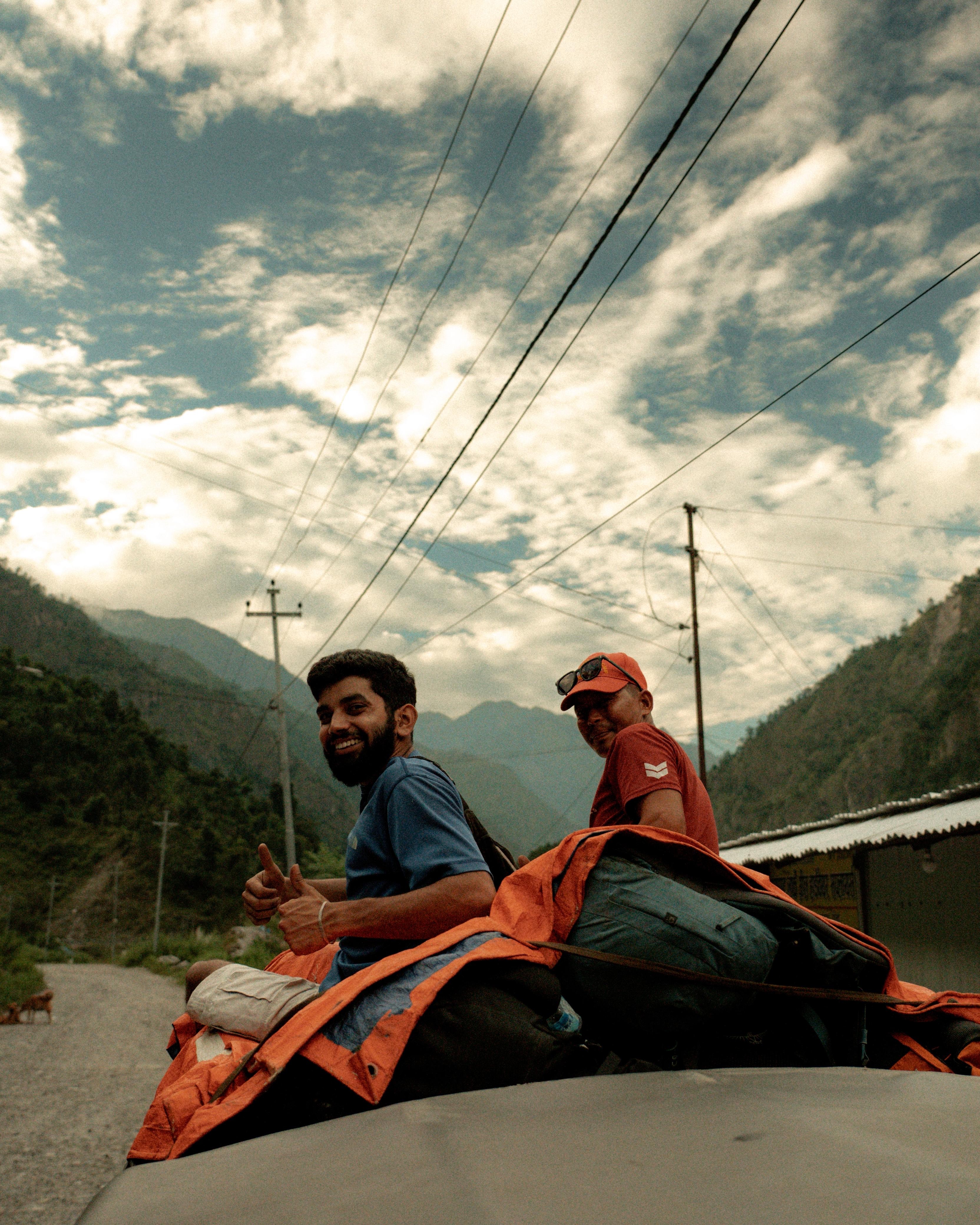Guides riding on top of a vehicle through mountain valley