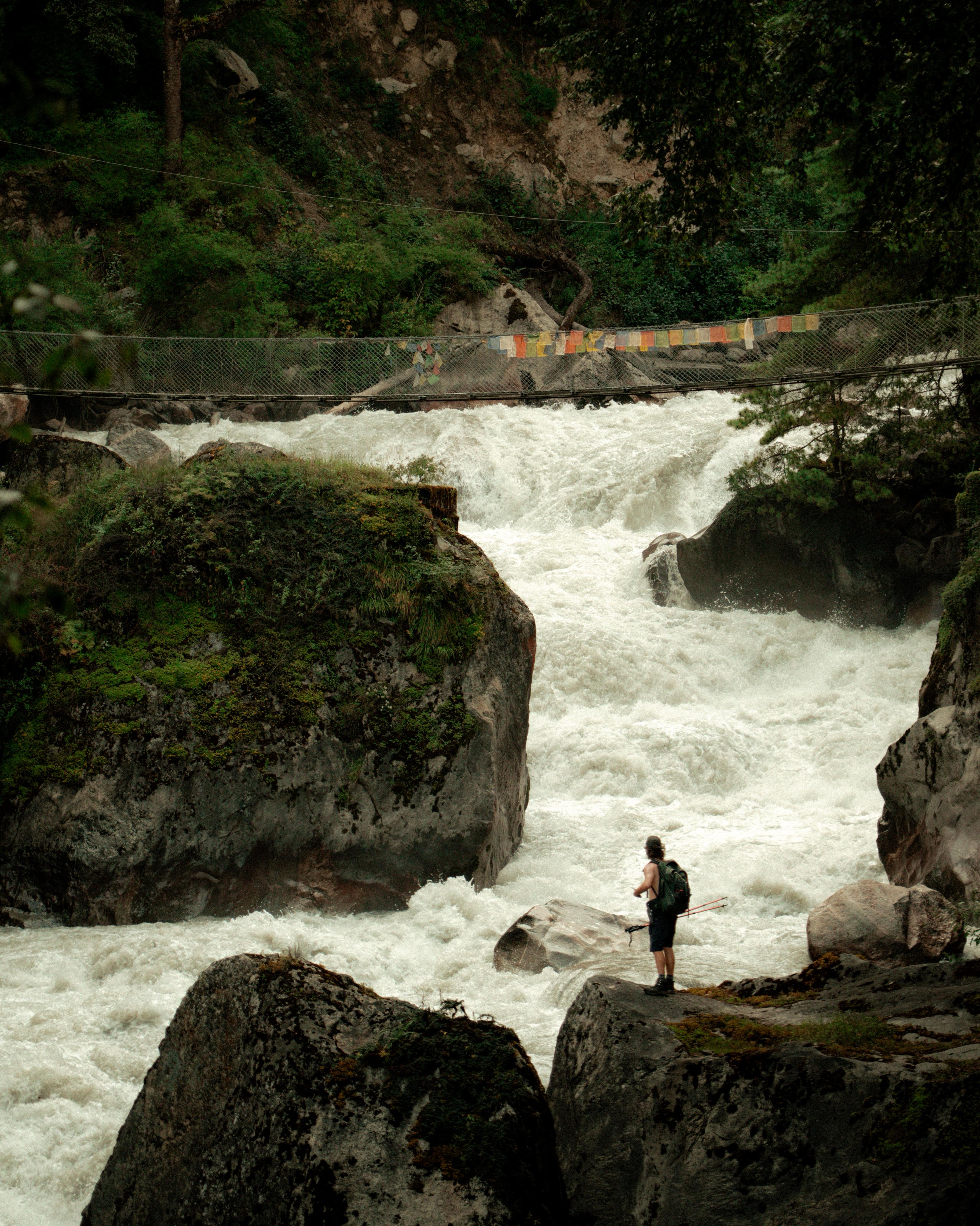 Trekker standing beside a rushing river on the Annapurna Circuit